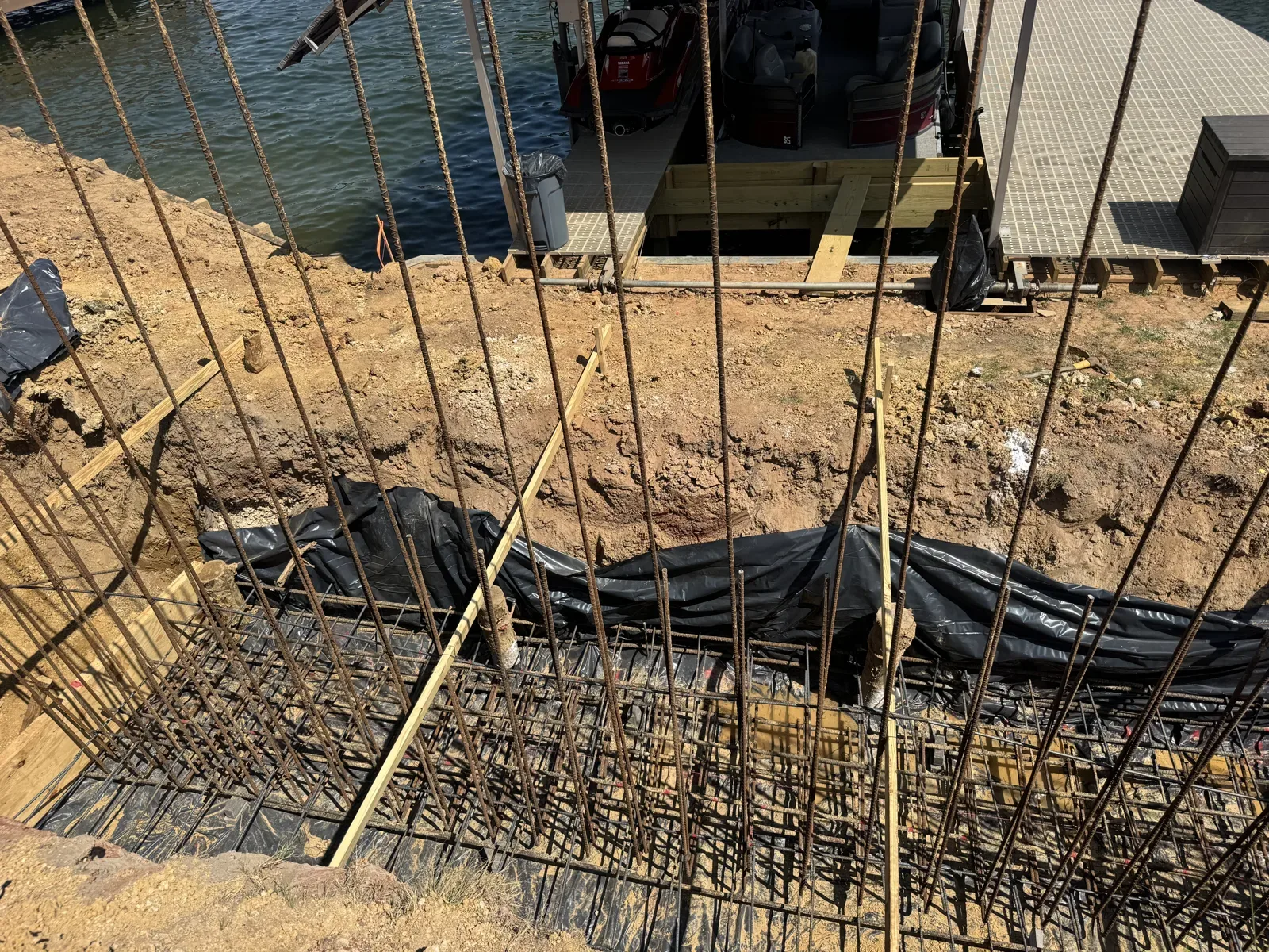 Tied rebar for a retaining wall footing over a vapor barrier near a boat dock